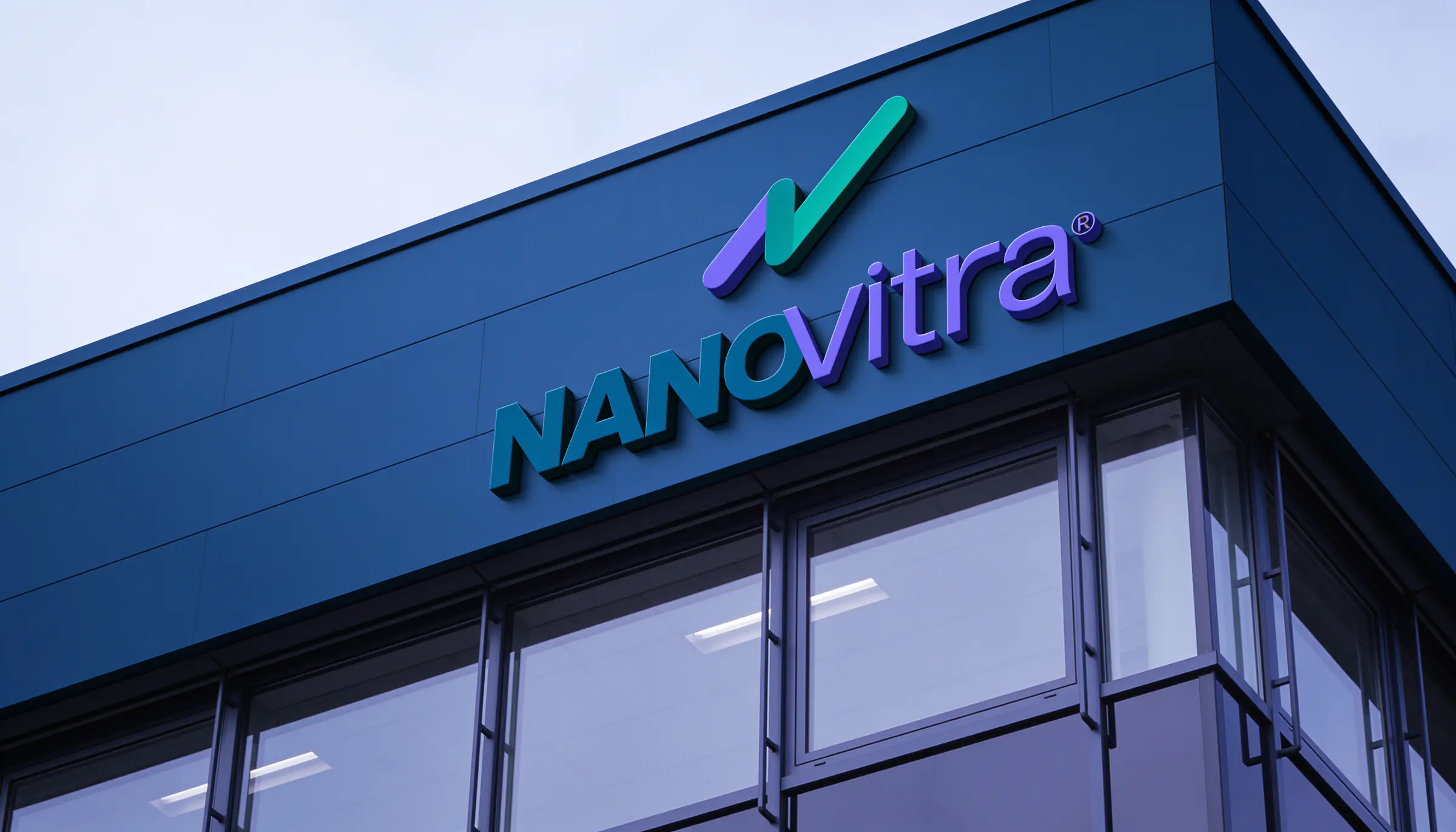 The NANOvitra sign on the facade of a modern glass headquarters building